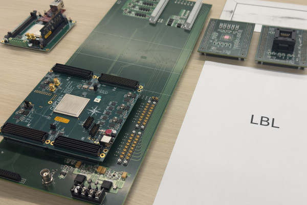 Computer hardware on a conference room table with a piece of paper that says LBL next to it.