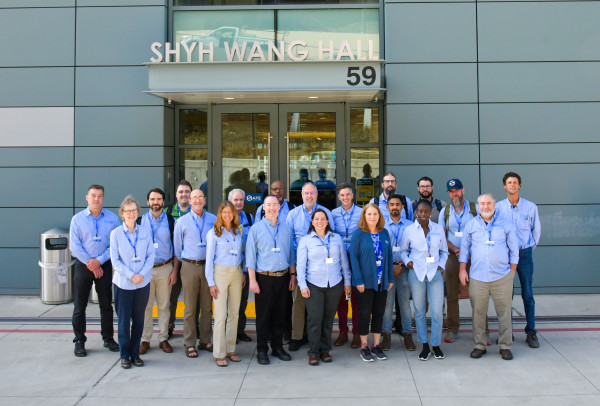 Large, diverse group photo of several rows of people standing in the entryway of a building at Berkeley Lab.